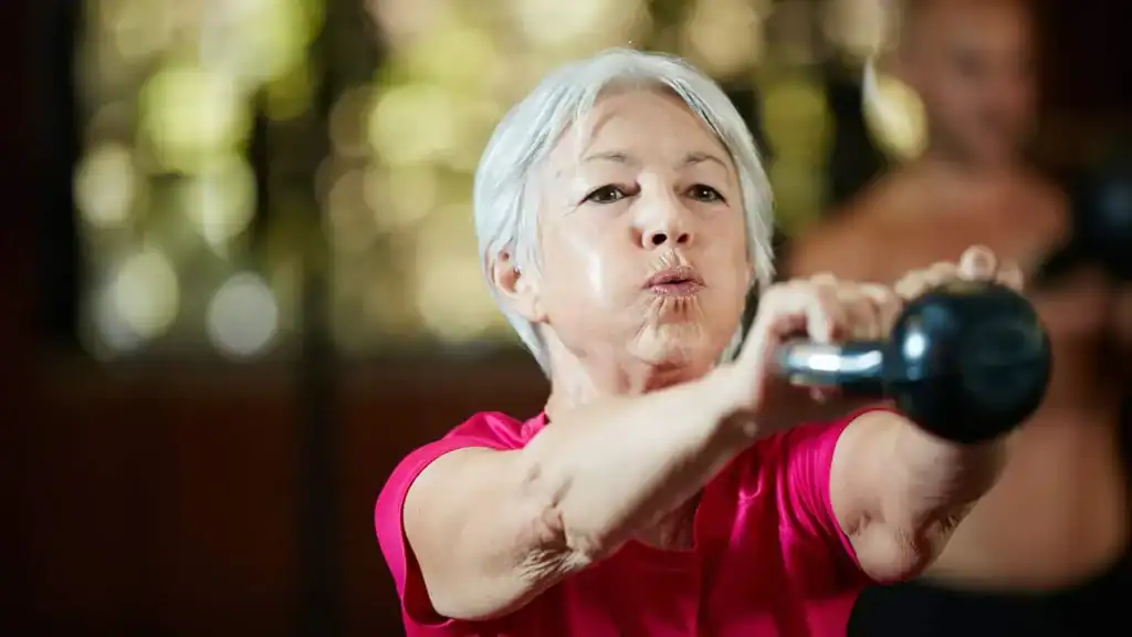 Older woman doing weight training Dorset to help her strength and longevity 
