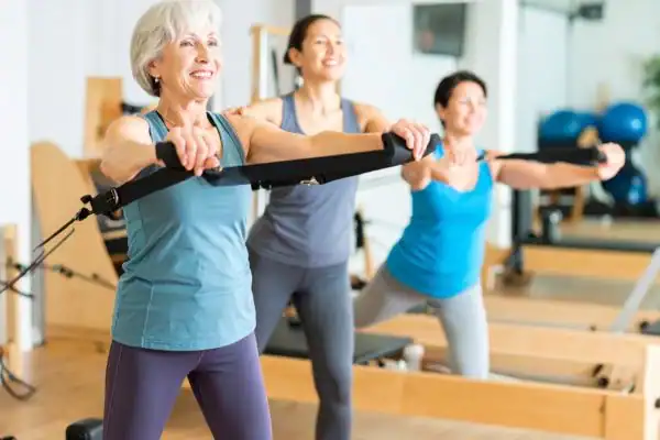 Toning Arms After 60: Empowering Womens Fitness Through Effective Weight Training 2 older woman doing weight training Dorset and resistance in the gym to tone upper arms