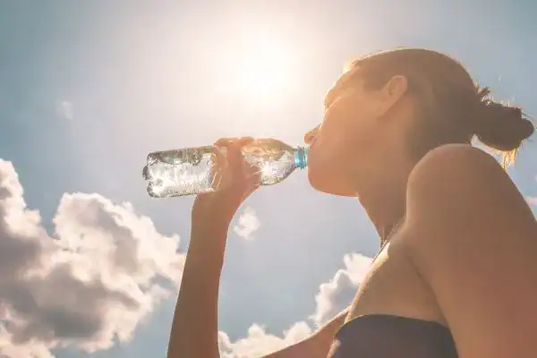 Hydration: The Secret Ingredient for a Toned Stomach and Enhanced Fitness 3 Image of woman drinking water to hydrate Dorset after run.